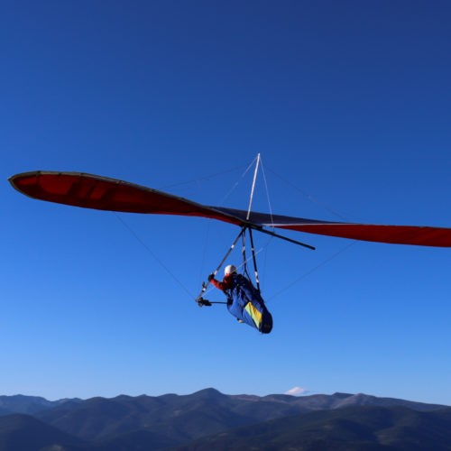 hang glider with blue sky and mountain range