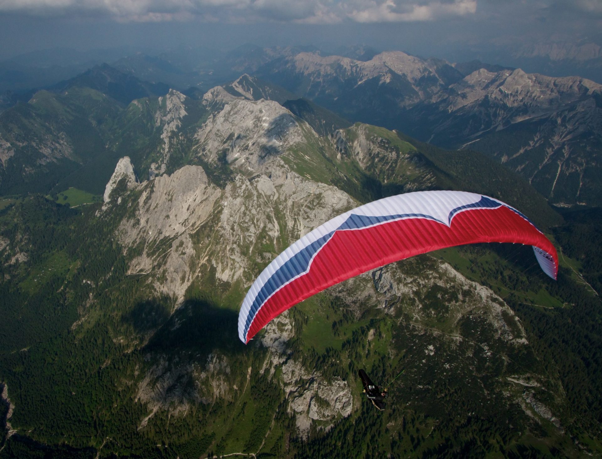 paraglider over green mountains